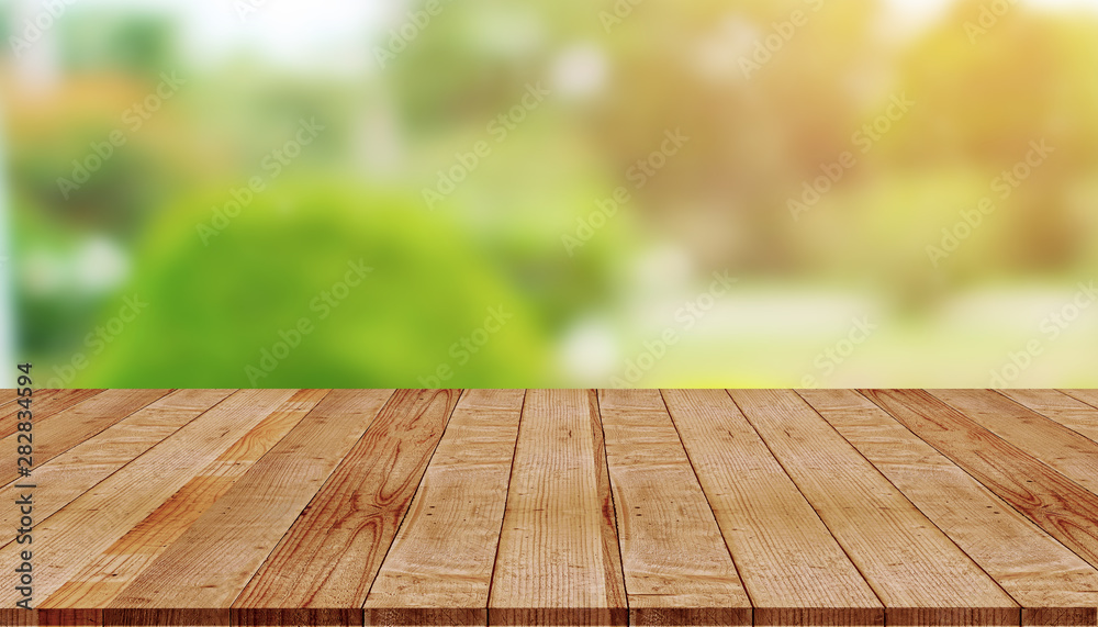 Empty wooden table with blur of green nature background Empty wooden table with blur of green nature background