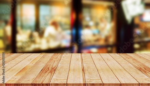 Empty wooden table with abstract blurred background of coffee shop