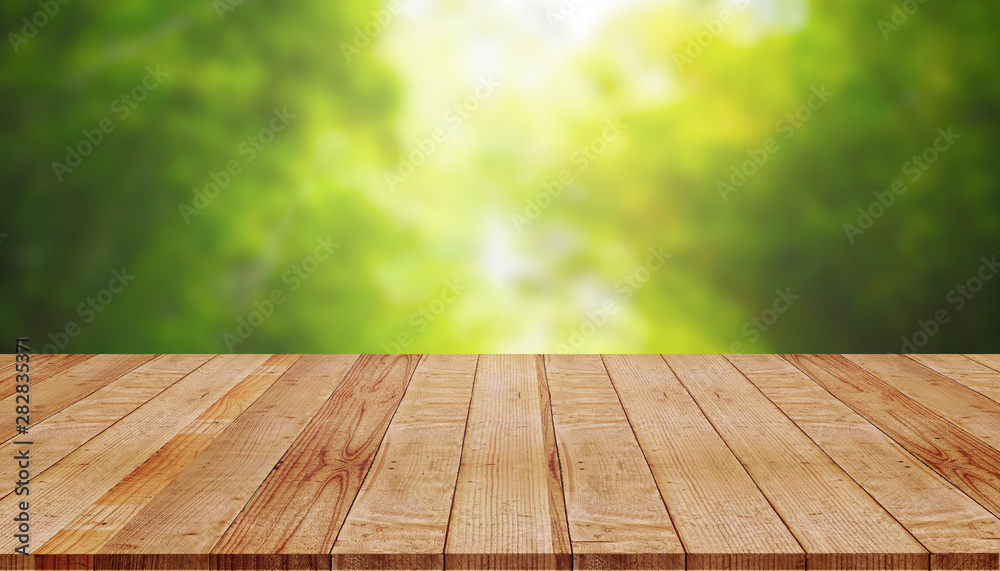 Empty wooden table with blur of green nature background