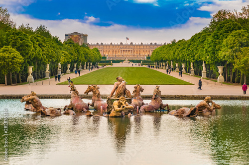 Great view of the Apollo Fountain (Bassin d'Apollon) in the classic French formal garden with the green carpet (Tapis Vert), the Latona Fountain (Bassin de Latone) and the Versailles Palace behind.