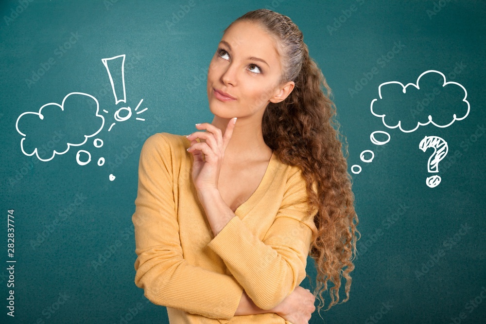 Portrait of thoughtful young woman on green background with signs Portrait of thoughtful young woman on green background with signs