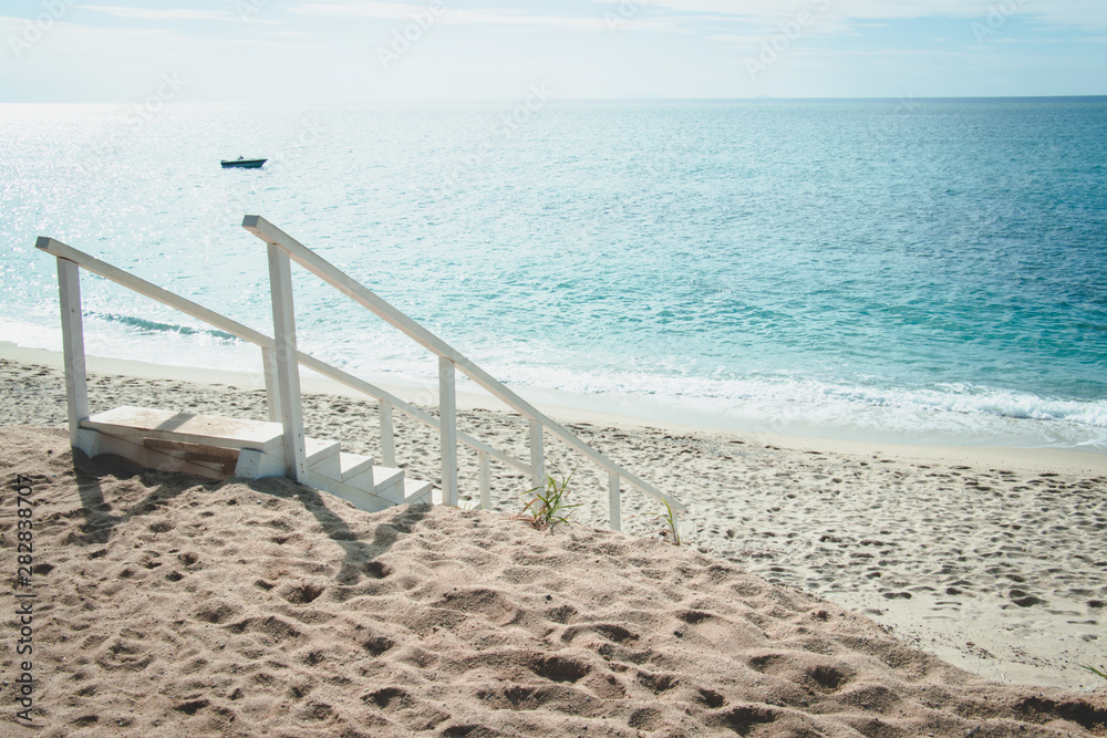 White stairs to the sea. Azure sea and white stairs on the beach.