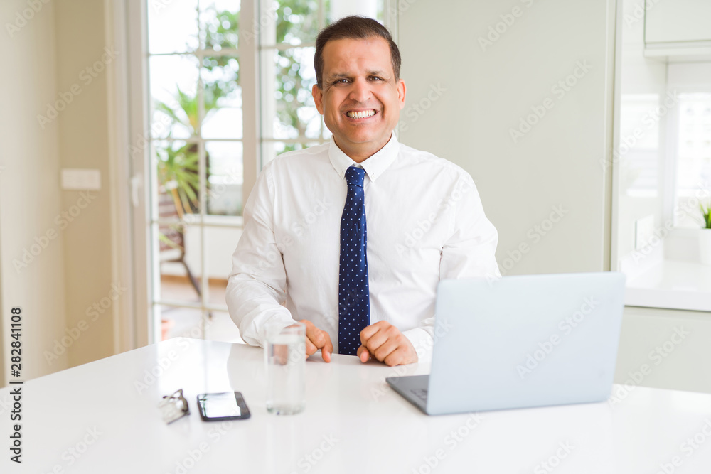 Middle age business man working with computer laptop with a happy and cool smile on face. Lucky person. Middle age business man working with computer laptop with a happy and cool smile on face. Lucky person.