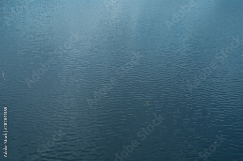 Water background with ripples, reflecting the landscape.