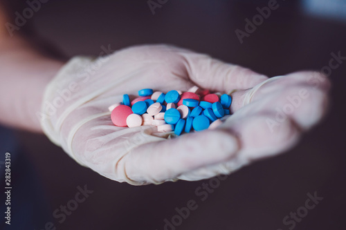 close-up of the doctor's hand with colorful pills
