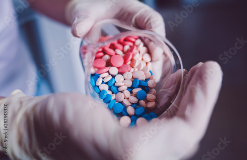 scientist doctor pours pills on his hand photo