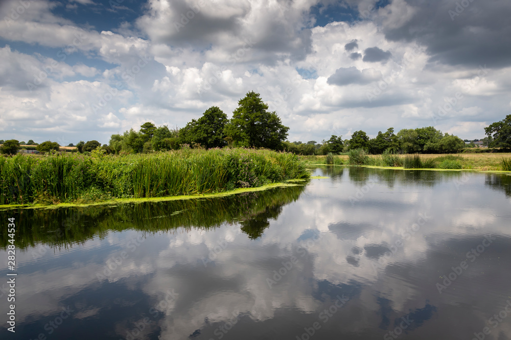 the river stour at fiddleford mill with clouds and reflections in river