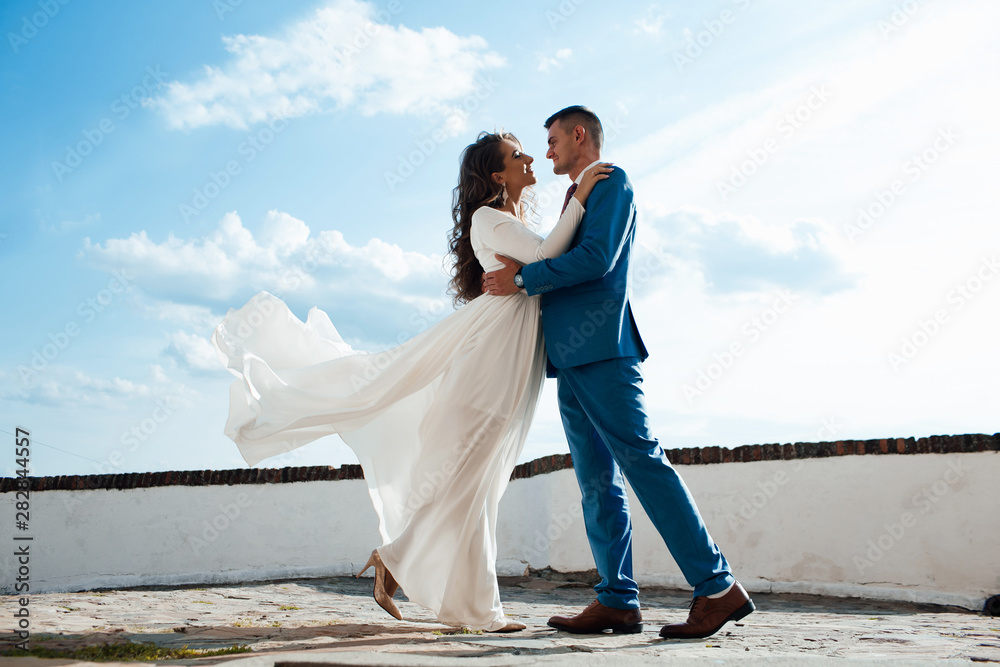 Amazing portrait of a wedding couple which is dancing near the old castle. They are holding their hands, dancing and spinning. Amazing portrait of a wedding couple which is dancing near the old castle. They are holding their hands, dancing and spinning.