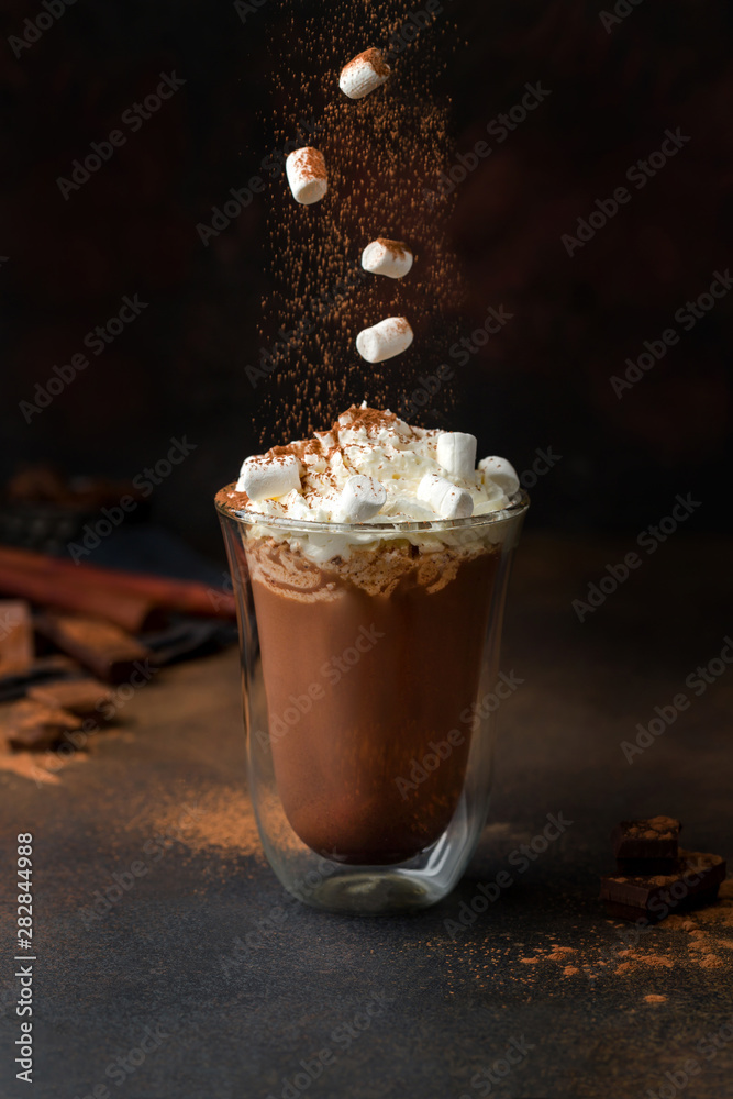 Fotobehang Chocolade hot chocolate with cream and marshmallow in a clear glass. marshmallow falling into cacao. #282844988