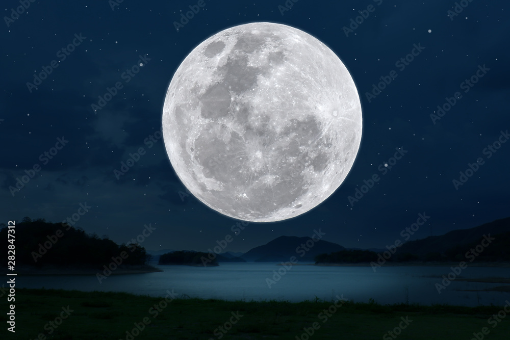 Full moon over lake in the dark night.