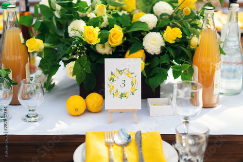 Elegant wedding table arrangement, floral decoration, restaurant. Wedding table setup. Wedding in the forest. Seat numbers. Lemon theme