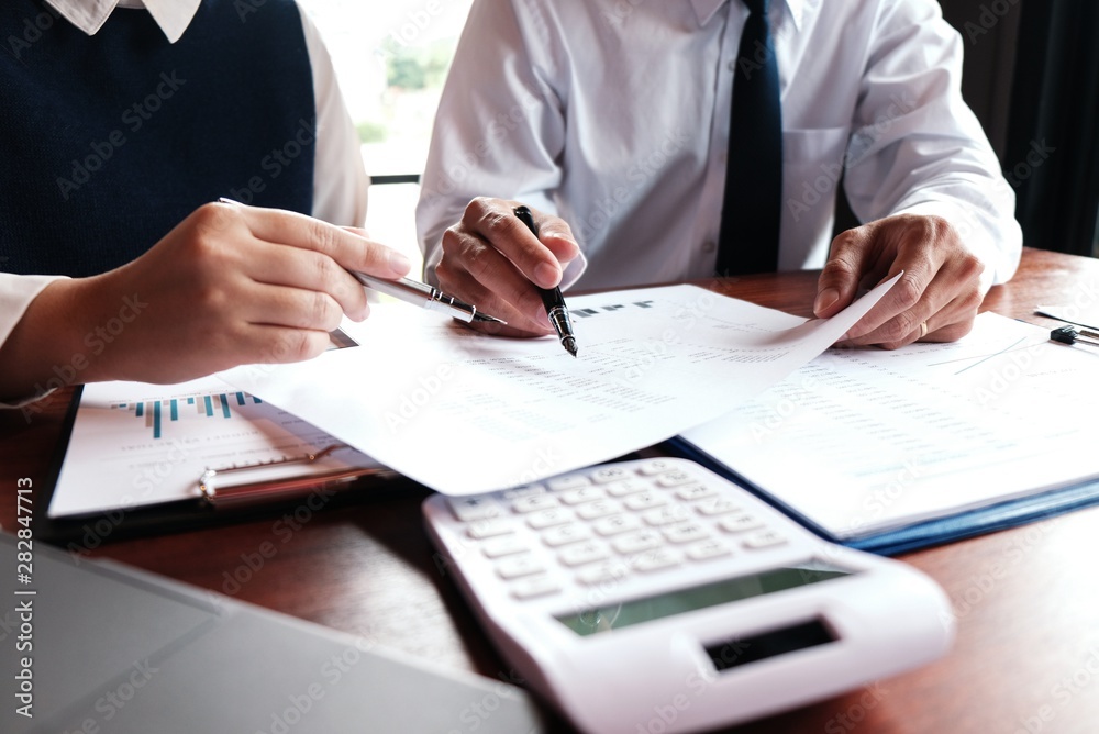 Businessman analyzing investment charts and pressing calculator buttons over documents. Accounting Concept. Businessman analyzing investment charts and pressing calculator buttons over documents. Accounting Concept.