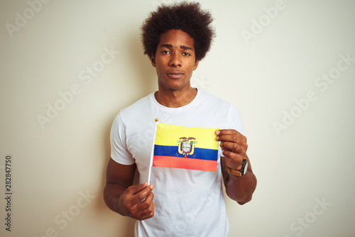 Afro american man holding Colombia Colombian flag standing over isolated white background with a confident expression on smart face thinking serious photo