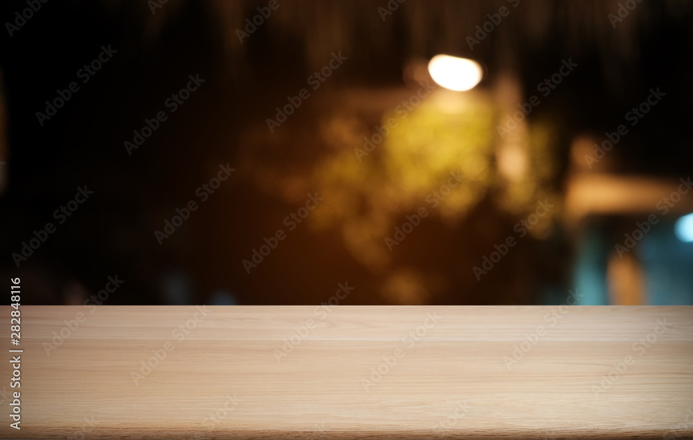 Empty dark wooden table in front of abstract blurred bokeh background of restaurant . can be used for display or montage your products.Mock up for space.