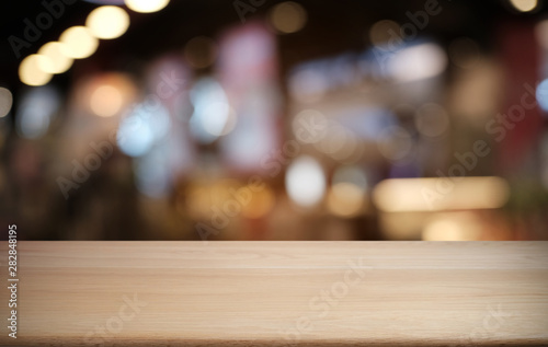 Empty dark wooden table in front of abstract blurred bokeh background of restaurant . can be used for display or montage your products.Mock up for space.