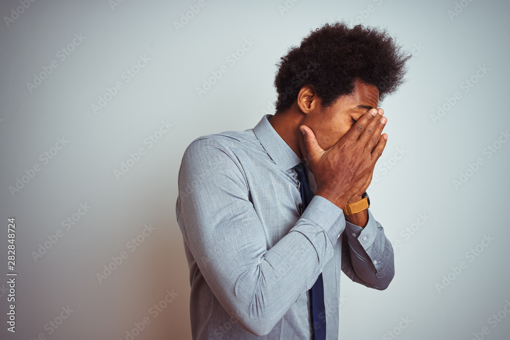 American business man with afro hair wearing shirt and tie over isolated white background with sad expression covering face with hands while crying. Depression concept. American business man with afro hair wearing shirt and tie over isolated white background with sad expression covering face with hands while crying. Depression concept.