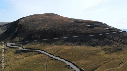 Twisting road on top of mountain in sunlight