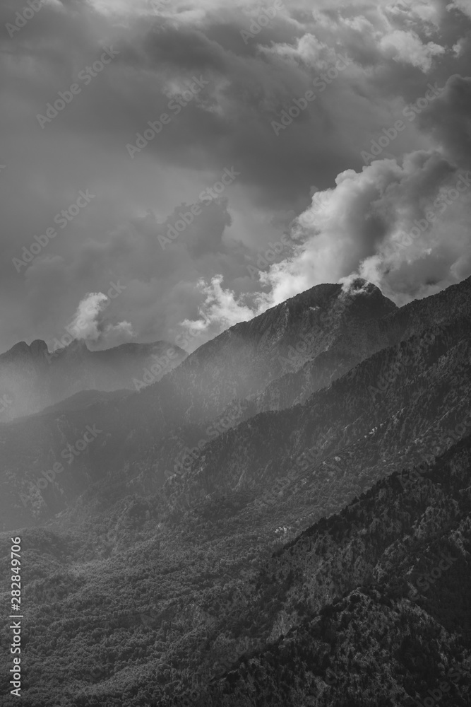 Black and white photography of amazing cloudy mountains. Vertcial color photography.