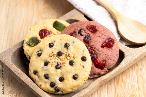 Mixed fruits cookie and Chocolate chip with wooden tray on the wood table. Delicious homemade baked cookie.