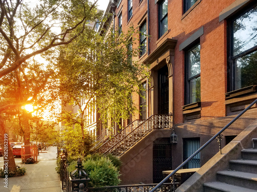 Old brownstone buildings along a quiet neighborhood street in Greenwich Village, New York City NYC