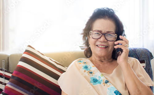 Old woman is happy for using mobile phone at home
