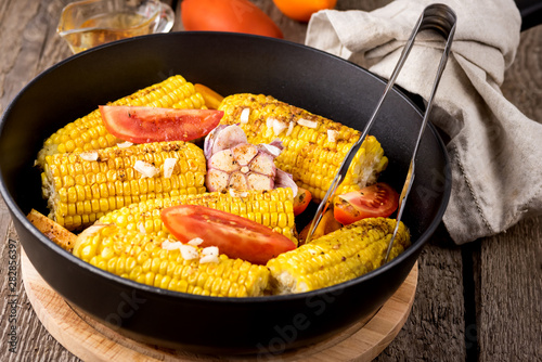 Fried Corn and Tomatoes in a Pan with Oil and Spices Tasty Grilled Vegetables Corn and Tomatoes Autumn Harvest Diet Food Dinned Wooden Background Close Up