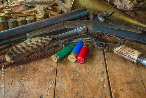 Beautiful hunting still life with vintage rifle, hunting knife, horn on the old wooden background with copy space