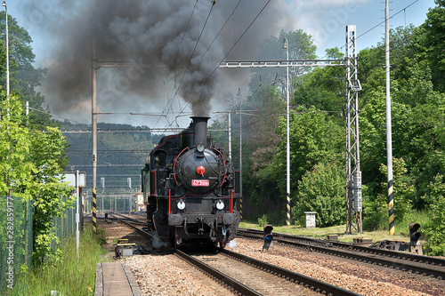 The steam locomotive departs from the station. Dense smoke rises from the chimney.