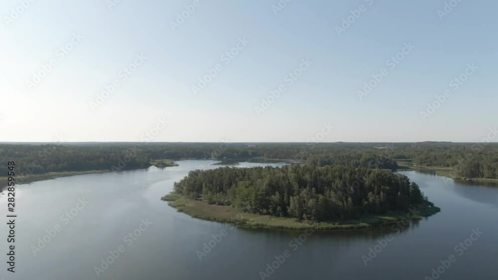 Flying over lake and island. River with ripples. Arial drone shot. Water and waves. Coast and wild forest. Flying over lake and island. River with ripples. Arial drone shot. Water and waves. Coast and wild forest.