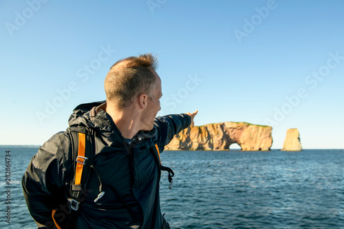 tourist man enjoying Perce Rock view from Gaspe in Quebec