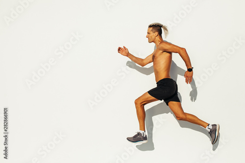 Fototapeta Naklejka Na Ścianę i Meble -  Man athlete sprinting on the street