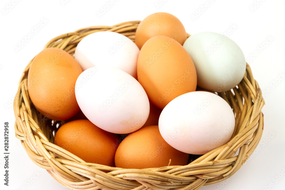 Fresh brown and white eggs in basket isolated on white background. Fresh brown and white eggs in basket isolated on white background.