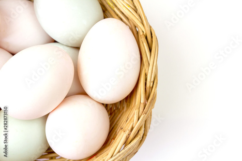 Fresh white eggs in basket isolated on white background.