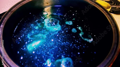 Blue liquid being boiled in a pot on the stove. photo