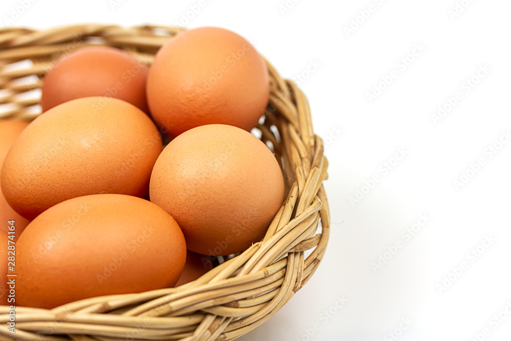 Fresh brown eggs in basket isolated on white background.