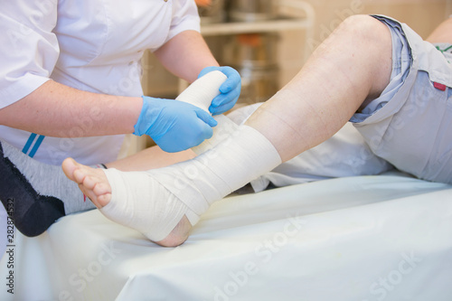 Foto Nurse bandages the leg