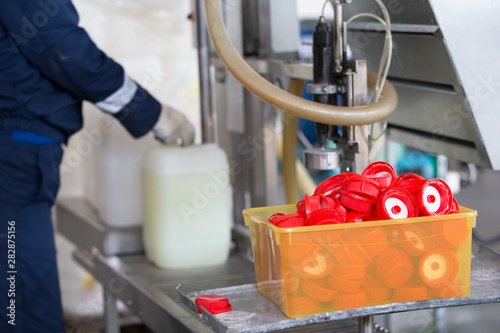 Industrial container for bottling and packaging chemicals.Hands of a worker poured into a plastic container.