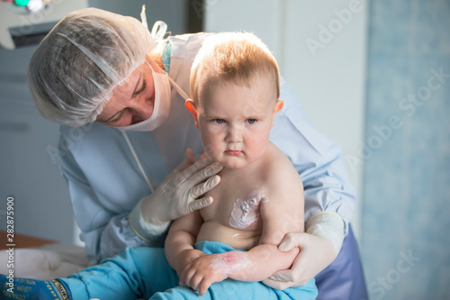  A little boy nurse treats a burn. A child in the hospital is injured. The doctor treats the baby. Little hospital patient. photo