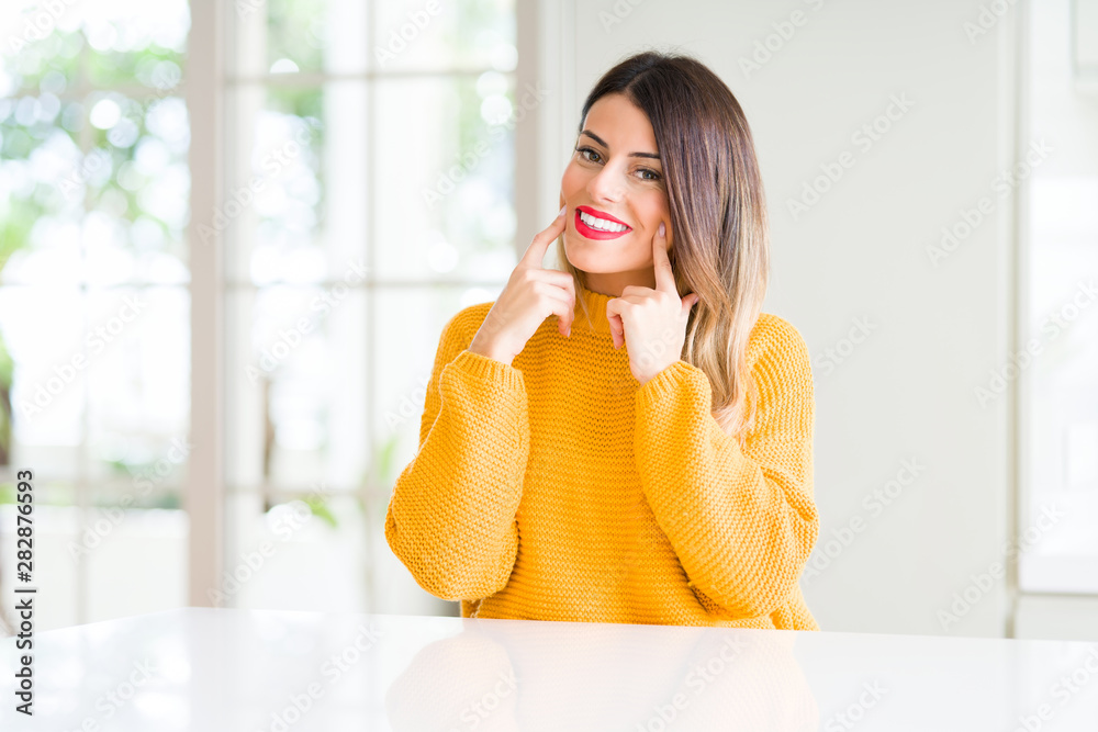 Young beautiful woman wearing winter sweater at home Smiling with open mouth, fingers pointing and forcing cheerful smile Young beautiful woman wearing winter sweater at home Smiling with open mouth, fingers pointing and forcing cheerful smile