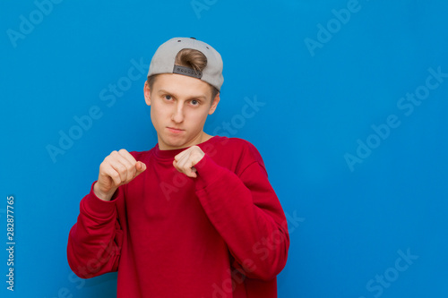A handsome sports man stands in a fighting pose, in gloves