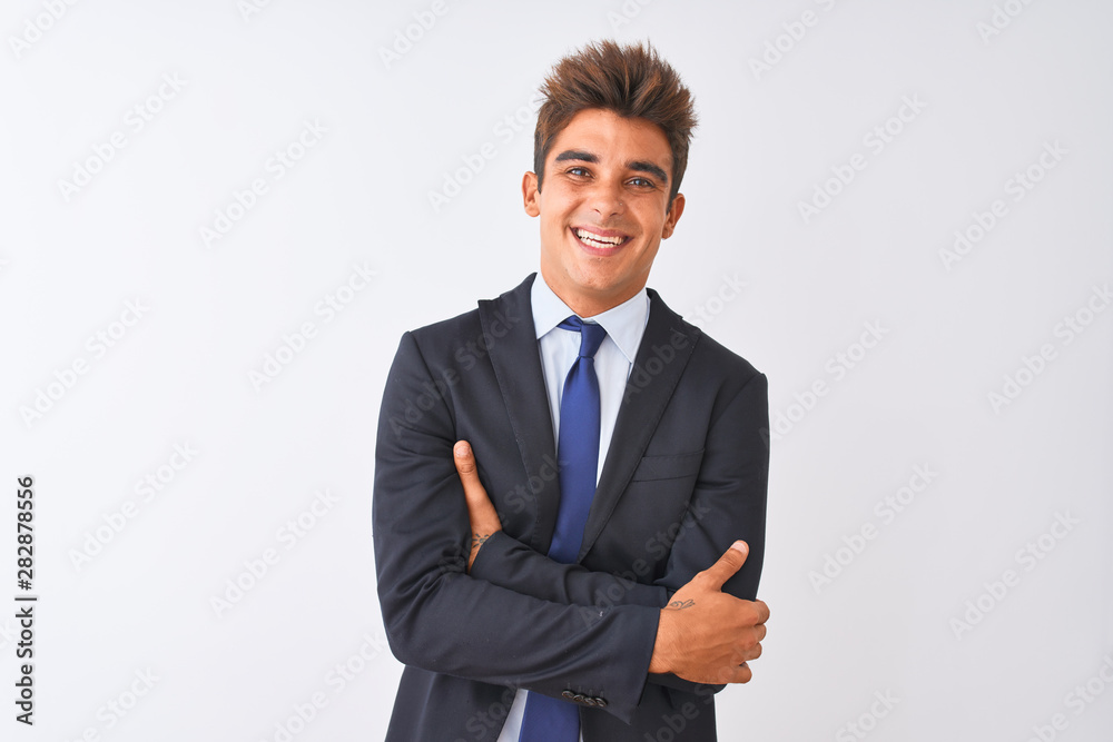 Young handsome businessman wearing suit standing over isolated white background happy face smiling with crossed arms looking at the camera. Positive person. Young handsome businessman wearing suit standing over isolated white background happy face smiling with crossed arms looking at the camera. Positive person.