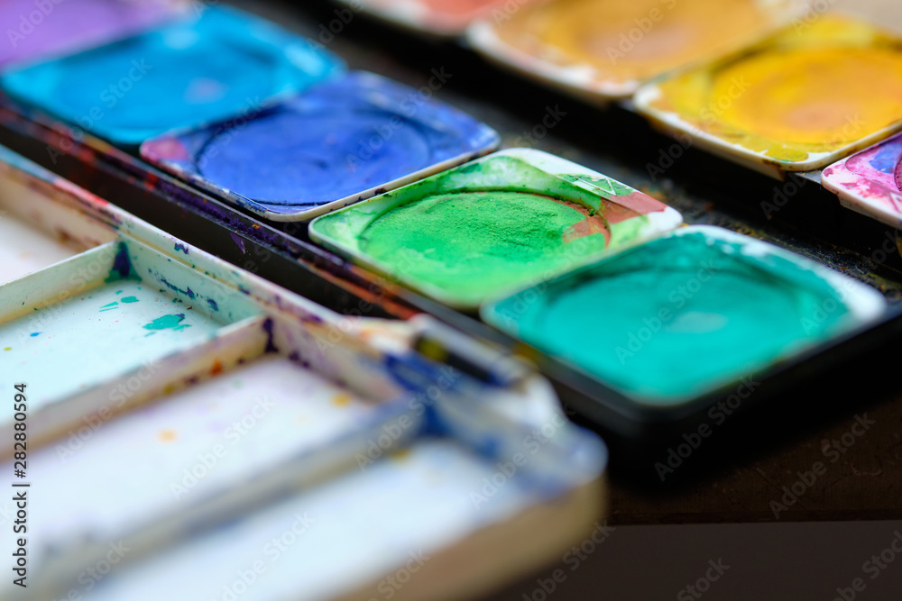 Closeup of an opened and used watercolor box with some different colors Closeup of an opened and used watercolor box with some different colors