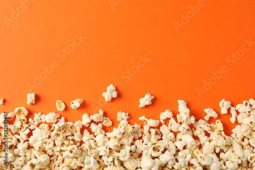 Flat lay composition with popcorn on orange background, copy space