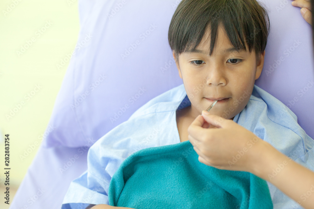 The doctor is measuring fever with Thermometer . Children who are sleeping sick in bed In a hospital, seriously ill children are staying for treatment. The doctor is measuring fever with Thermometer . Children who are sleeping sick in bed In a hospital, seriously ill children are staying for treatment.
