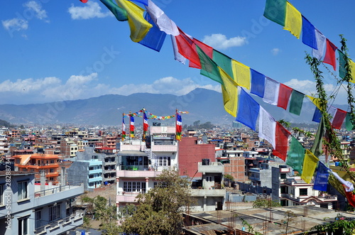 Magnigicient panoramic roof top view on sunny Kathmandu with its famous flags at the forefront, capital of Nepal