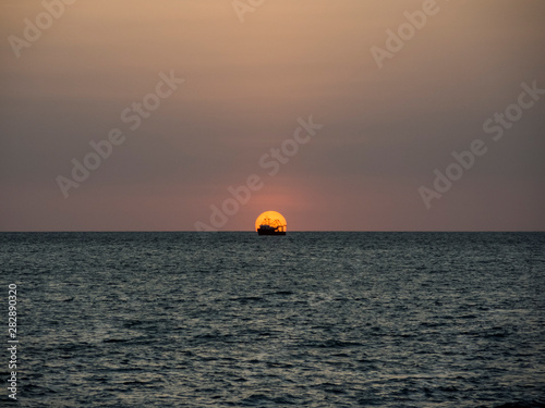 sunset over the sea with a boat © cribea
