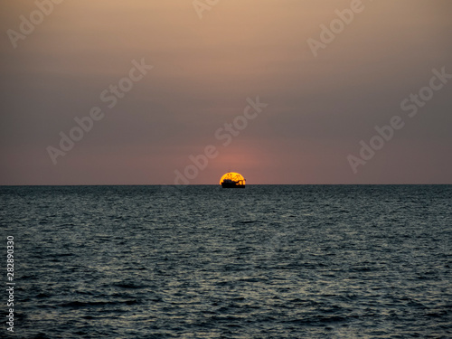 sunset over the sea with a boat