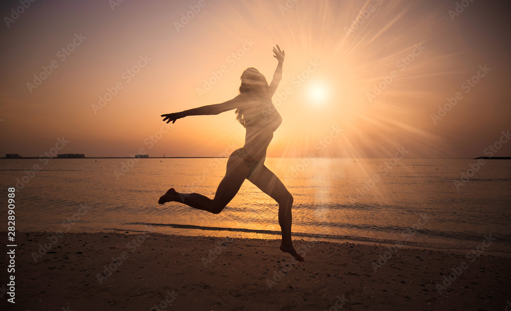 UAE. Woman sea, jump, sunset