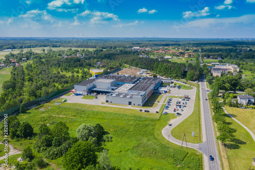 Aerial view of goods warehouse. Logistics center in industrial city zone from above. Aerial view of trucks loading at logistic center. View from drone