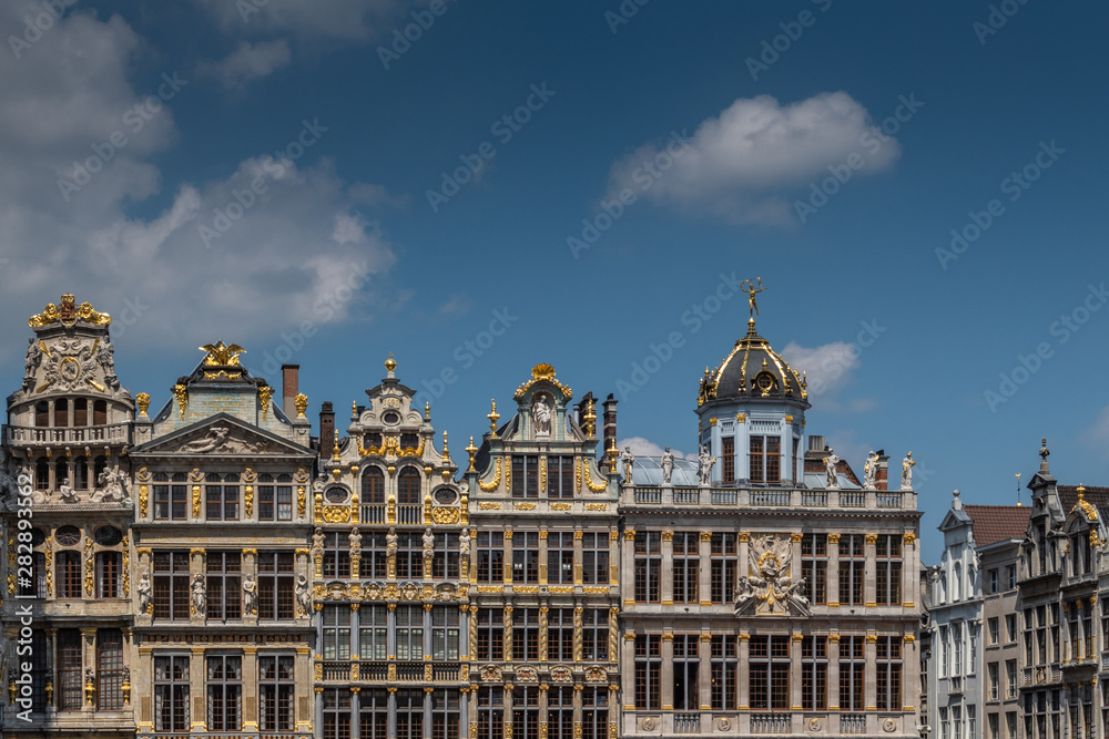 Brussels, Belgium - June 22, 2019: Beige stone facades and gables with statues on top at northwest side of grand Place. 
